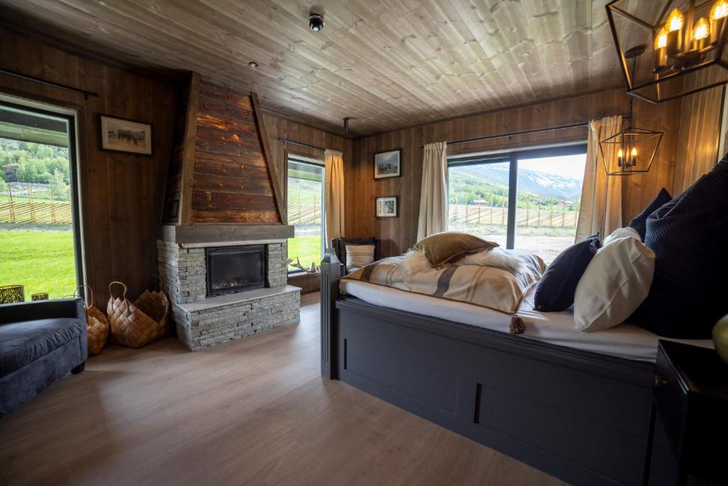 a bedroom with a bed and a fireplace at Fjelleventyret gårdsovernatting in Skjåk