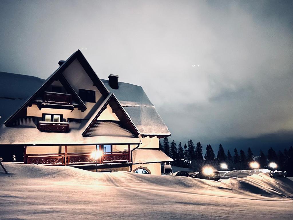 dom w śniegu z zapalonymi światłami w obiekcie Harmatówka Concept Mountain w Bukowinie Tatrzańskiej