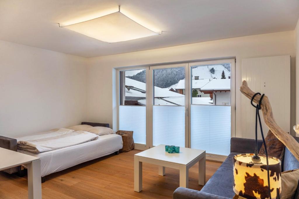 een woonkamer met een bed en een groot raam bij Haus Excelsior Top 30 in Seefeld in Tirol