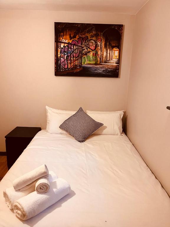 Un dormitorio con una cama blanca con toallas. en 'Woodbury' at stayBOOM en Lancaster