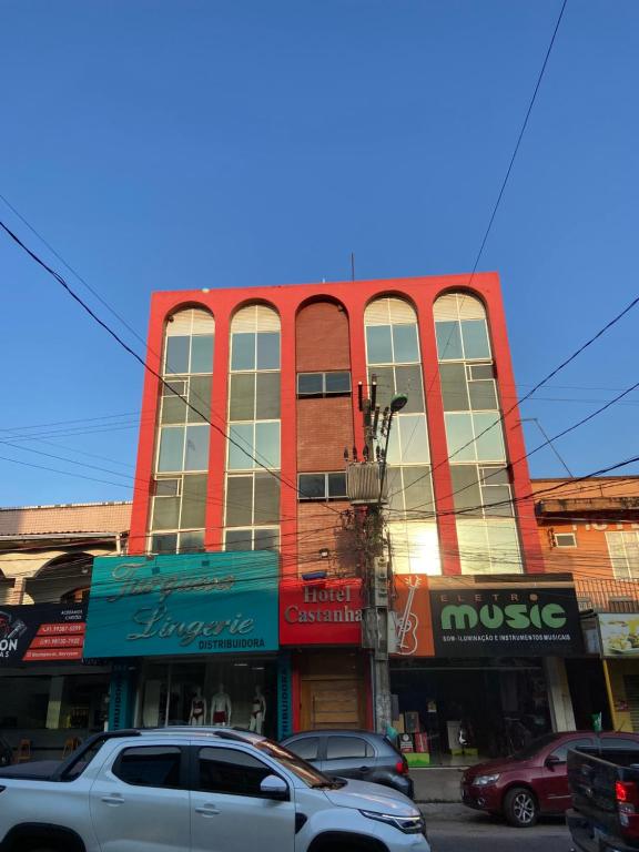 a tall building with cars parked in front of it at Hotel Castanhal in Castanhal