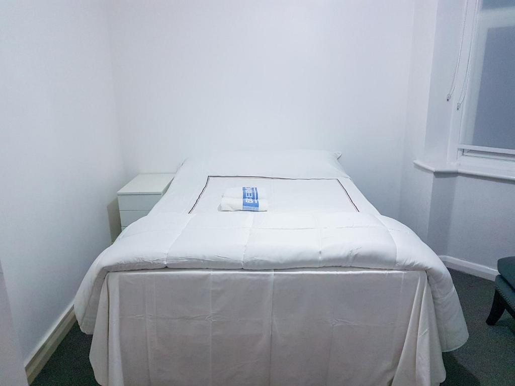 uma cama com um lençol branco num quarto em Grosvenor court em Londres