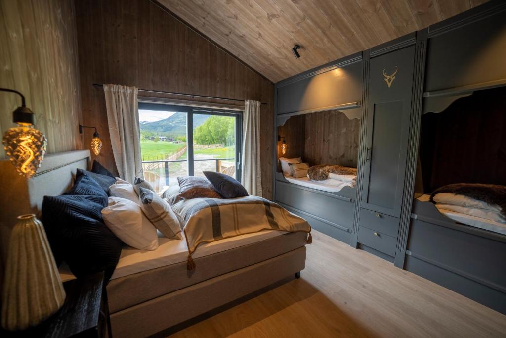 een slaapkamer met een bed en een groot raam bij Fjelleventyret gårdsovernatting in Skjåk