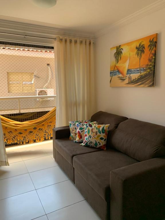 a living room with a couch and a window at Jóia Rara pertinho da Praia! in João Pessoa