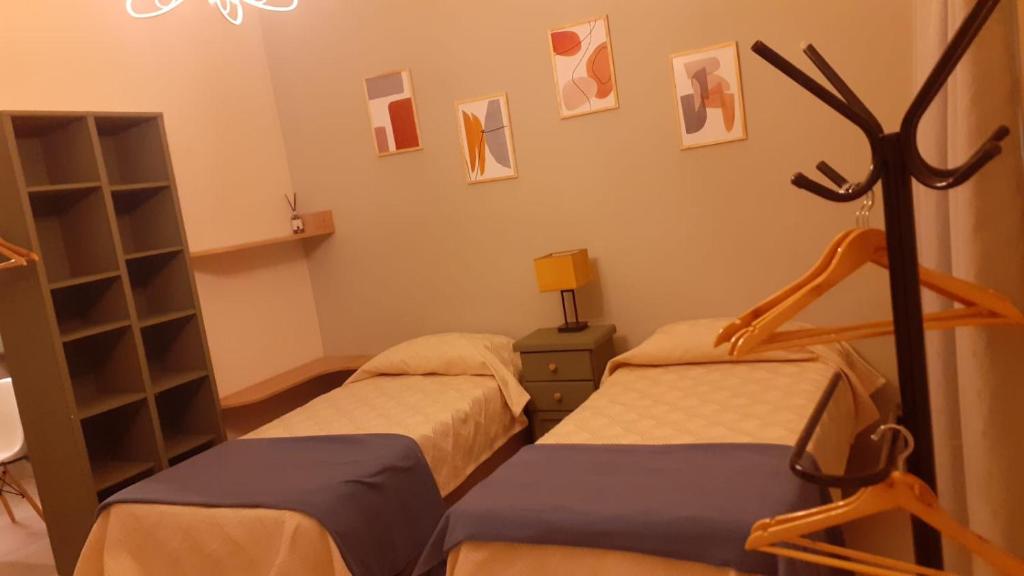 una habitación con 2 camas y un estante con fotografías en MirAle en Salta
