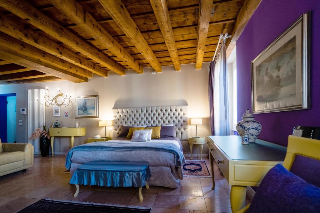 a bedroom with purple walls and a bed and a couch at Mazzini Suite in Verona