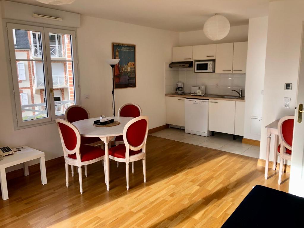 a kitchen and dining room with a table and chairs at Villa Médicis Trouville-sur-mer in Trouville-sur-Mer