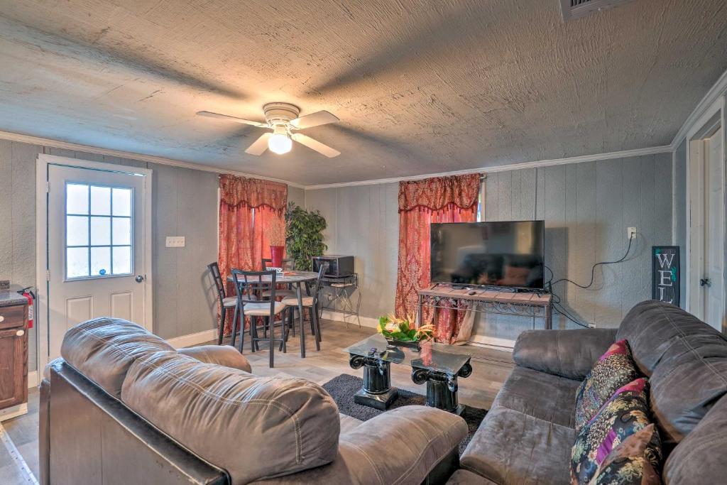 a living room with a couch and a television and a table at Shreveport Vacation Rental Near Riverfront in Shreveport