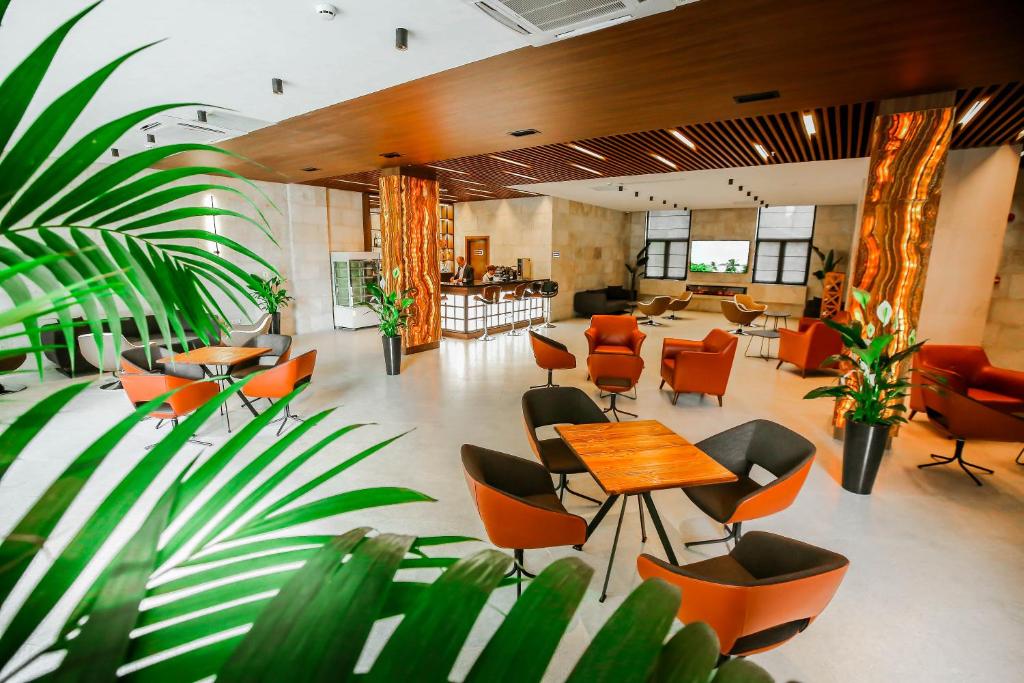 a lobby with a table and chairs and plants at Kutaisi Inn in Kutaisi