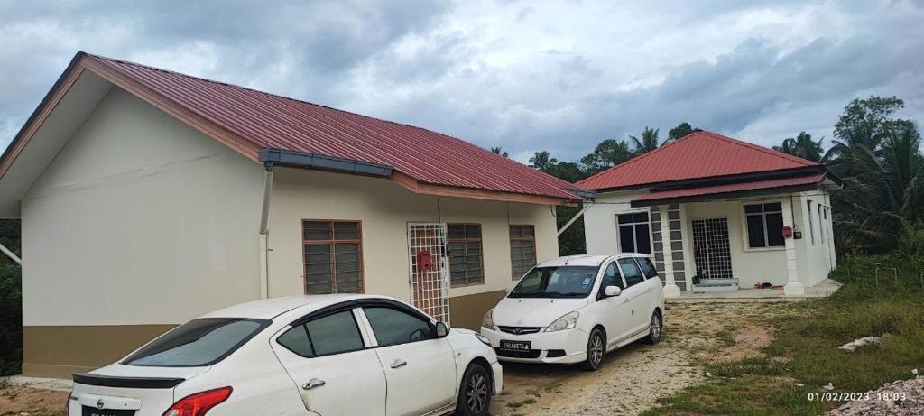 two cars parked in front of a house at MESRA MUSAFIR HOMESTAY 