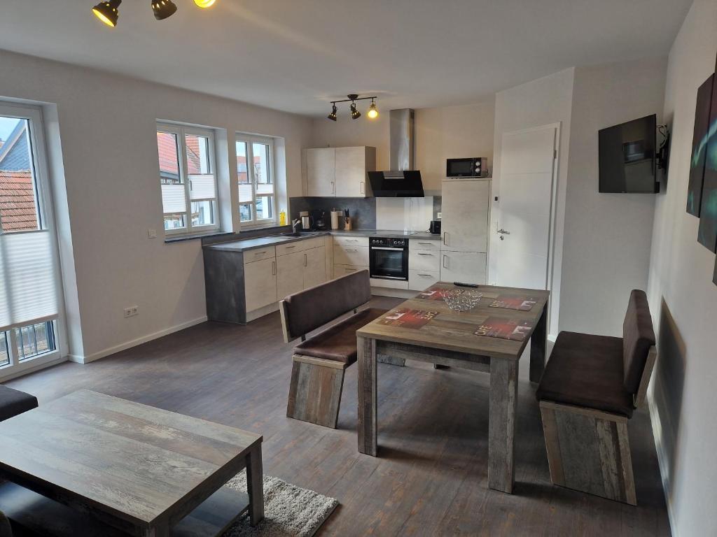 ein Wohnzimmer mit einem Tisch und einer Küche in der Unterkunft DM Hotes & Apartments - Apartment Rasenweg in Dingelstädt