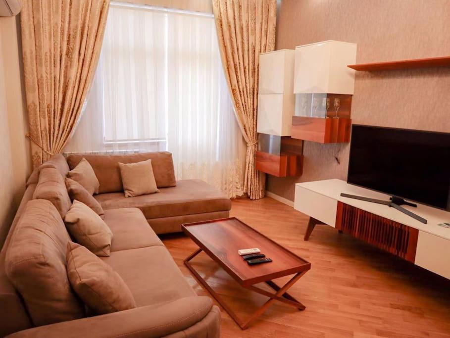 a living room with a couch and a tv at Explore Baku from YSB Apartment in Baku