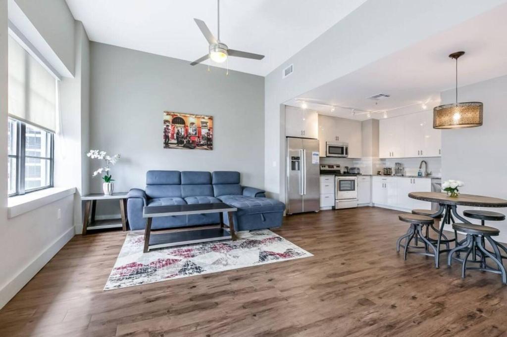 uma sala de estar com um sofá azul e uma mesa em Cozy Condo 5-minute Walk to French Quarter em Nova Orleans