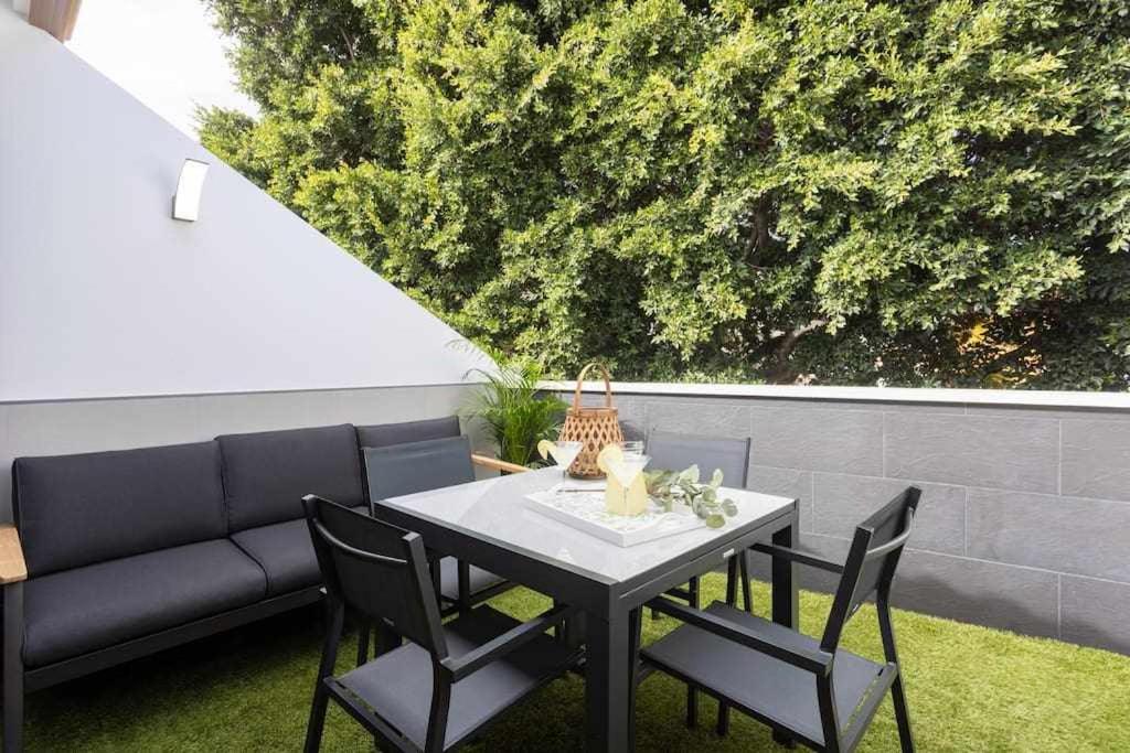 a table and chairs on a patio with a couch at Sunnyland Ático Adelfas San Andrés in San Andrés