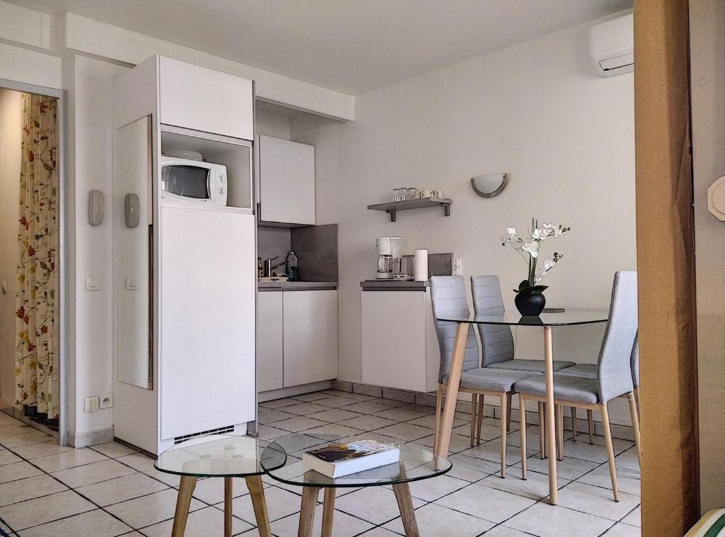 une petite cuisine et salle à manger avec une table et des chaises dans l'établissement Résidence Graziella Studio 303, à Juan-les-Pins