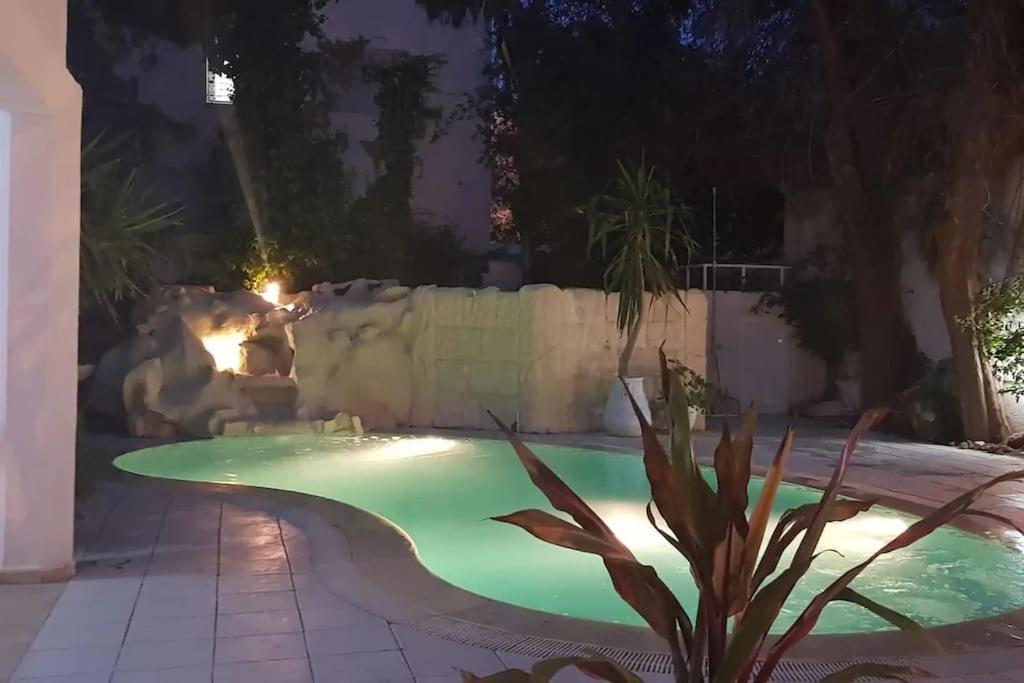 a swimming pool in a yard at night at Villa Carthagene /Jacuzzi -swimingpool- Billard in Sidi Daoud