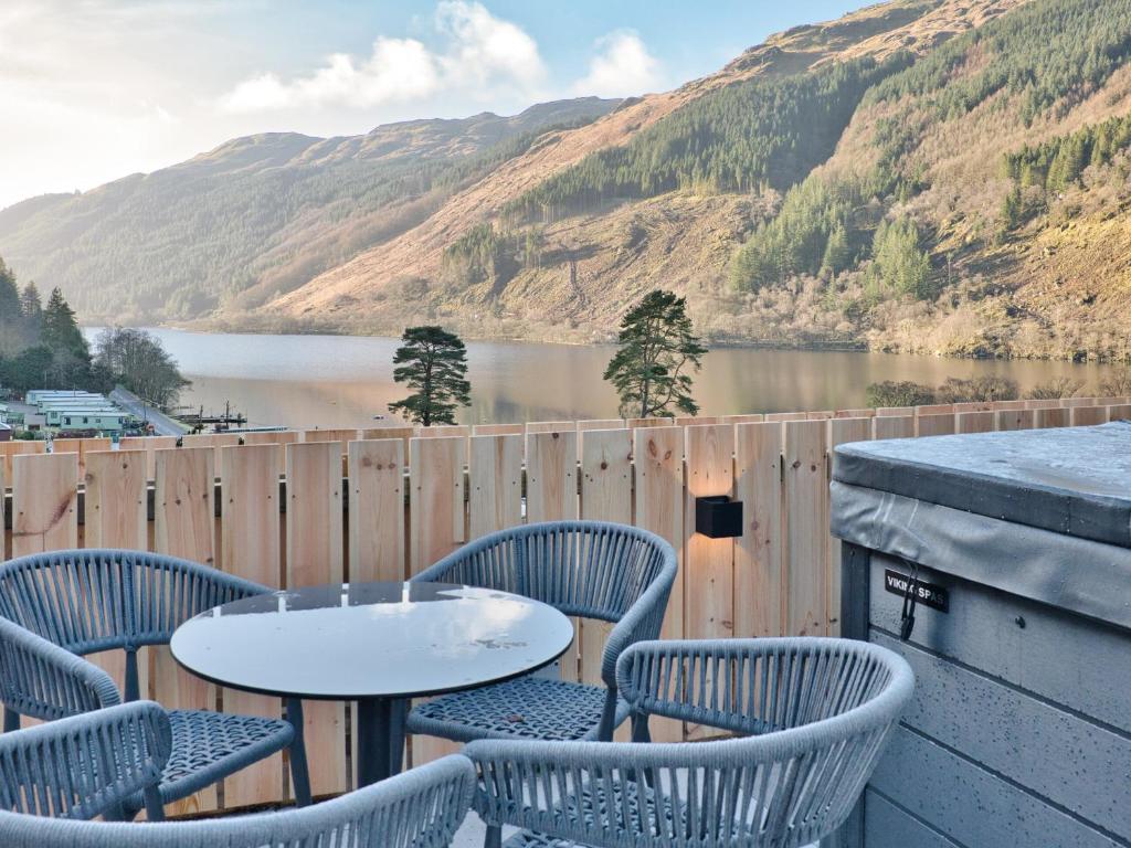 a table and chairs on a balcony with a view of a lake at Cur Cottage - Uk7809 in Coirantee