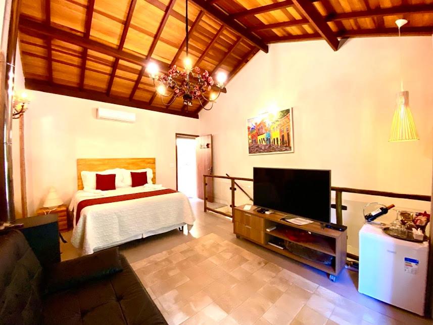 a bedroom with a bed and a flat screen tv at Espaço Viverde Penedo in Penedo