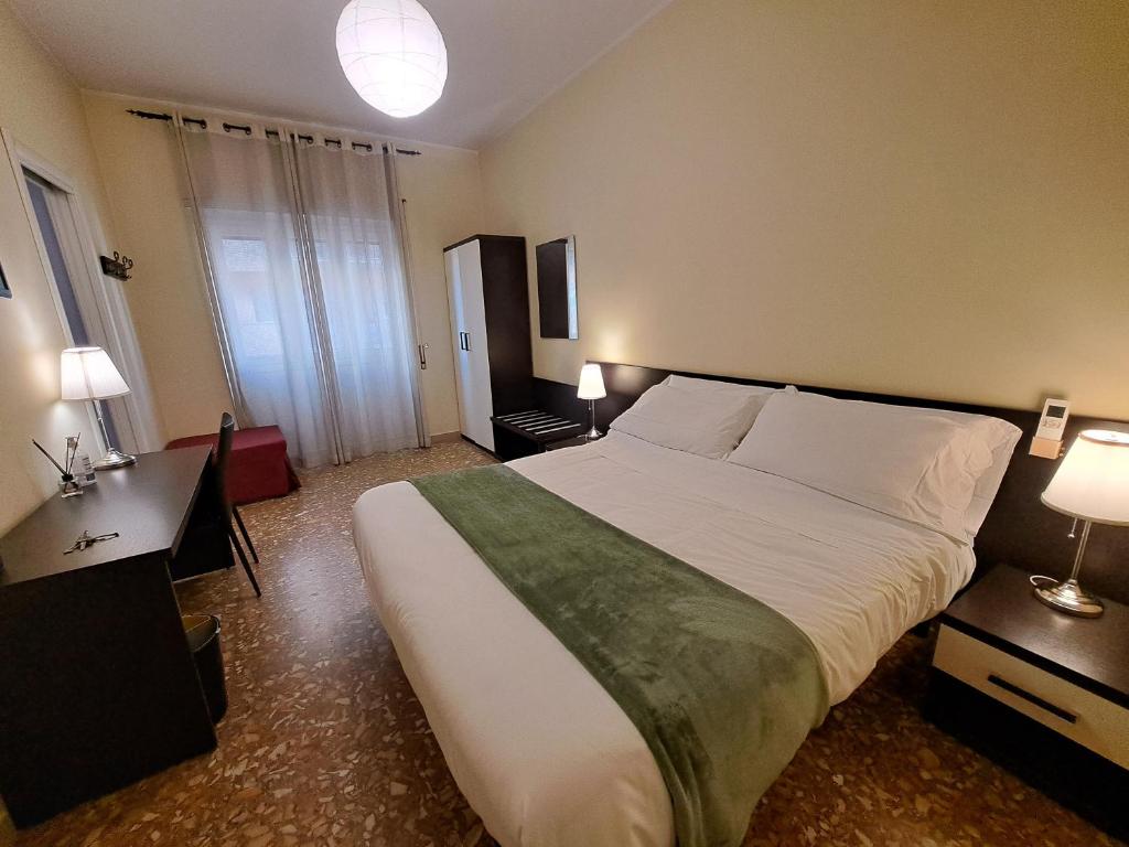 ローマにあるエコ B ＆ B マレラの大きなベッドとデスクが備わるホテルルームです。
