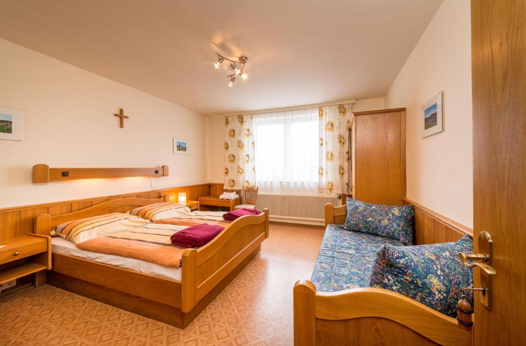 a bedroom with two beds and a cross on the wall at Gasthaus Bauer in Grafenschlag