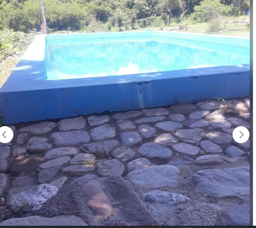 einen Pool mit Steinboden und einer blauen Badewanne in der Unterkunft Los Crespones, Vaqueros in Vaqueros