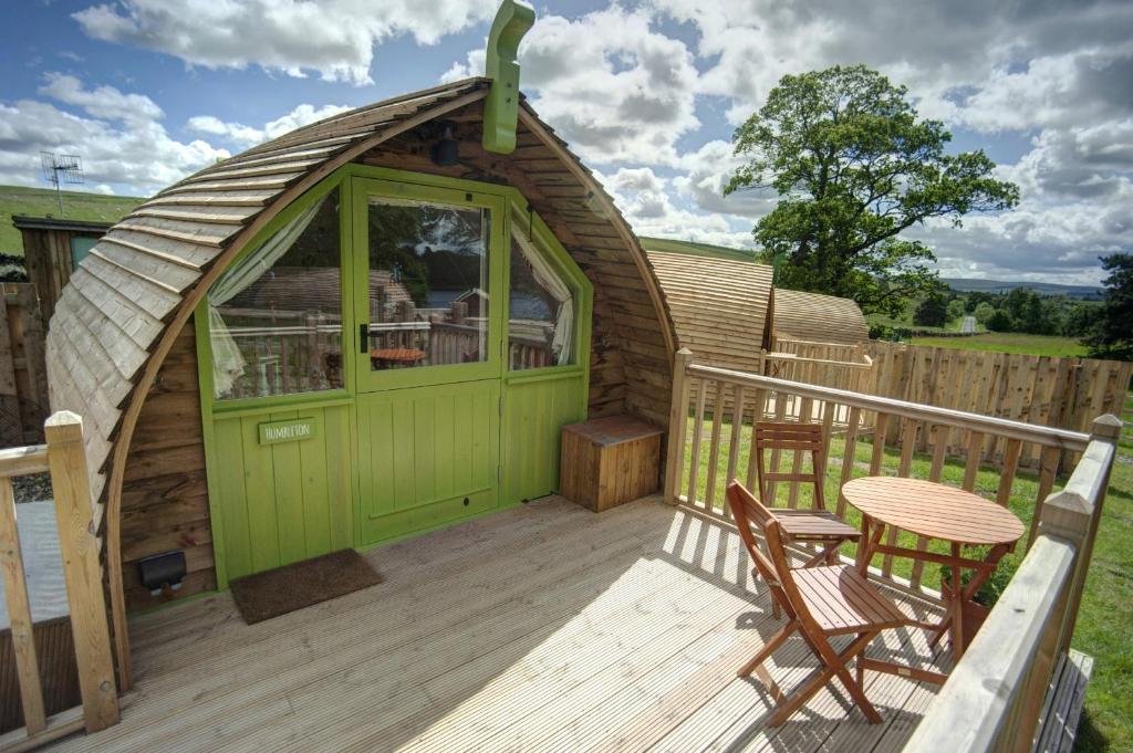 a green gazebo with a table and chairs on a deck at Finest Retreats - Humbleton Glamping in Hexham