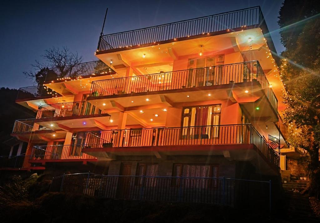 達蘭薩拉的住宿－The Unmad - Dharamkot，一座在晚上有灯的大建筑