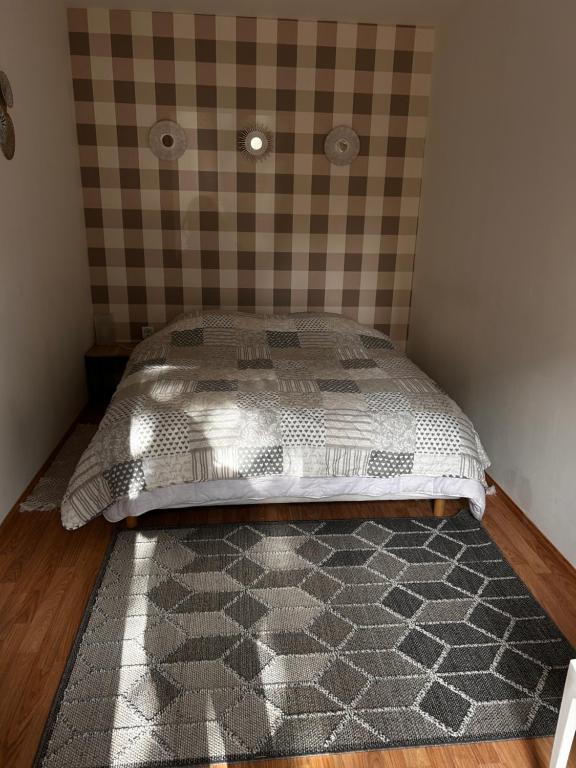 a bedroom with a bed with a checkered wall at Studio indépendant Lisieux in Lisieux