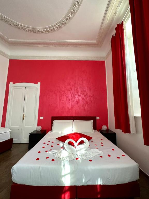 Dormitorio rojo con cama blanca y pared roja en Il Tempio Della Capitale, en Roma