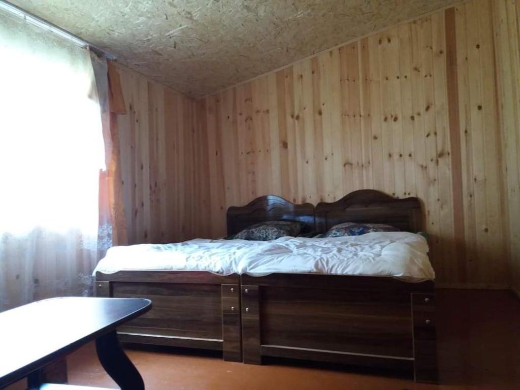 Bett in einem Zimmer mit einer Holzwand in der Unterkunft LIO in Glola