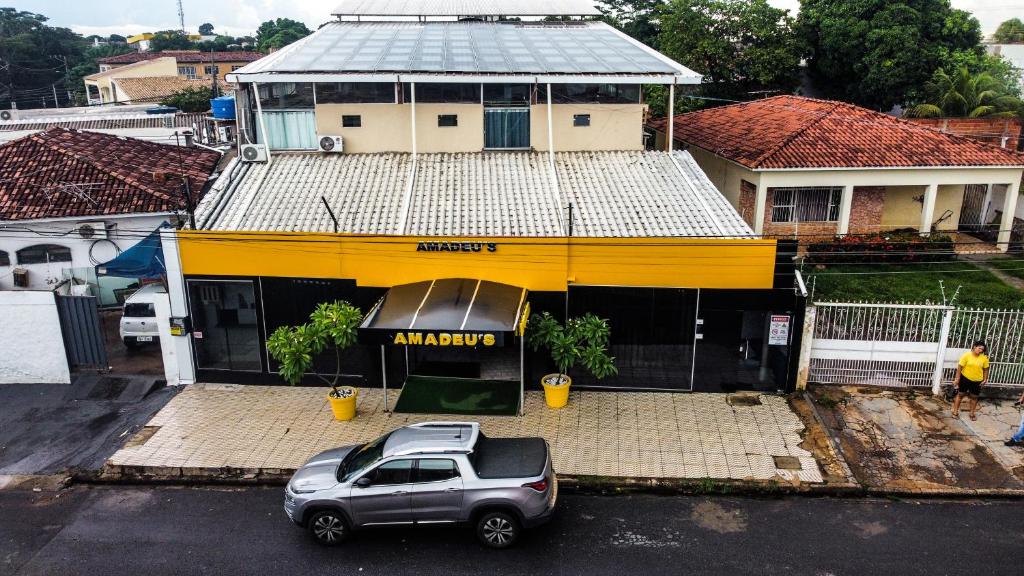 um carro estacionado num parque de estacionamento em frente a um edifício em Hotel Amadeu´s em Cuiabá