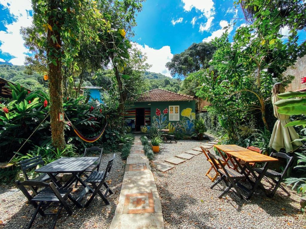 Mambembe Hostel - Ilha Grande في أبراو: فناء به طاولات وكراسي أمام المنزل