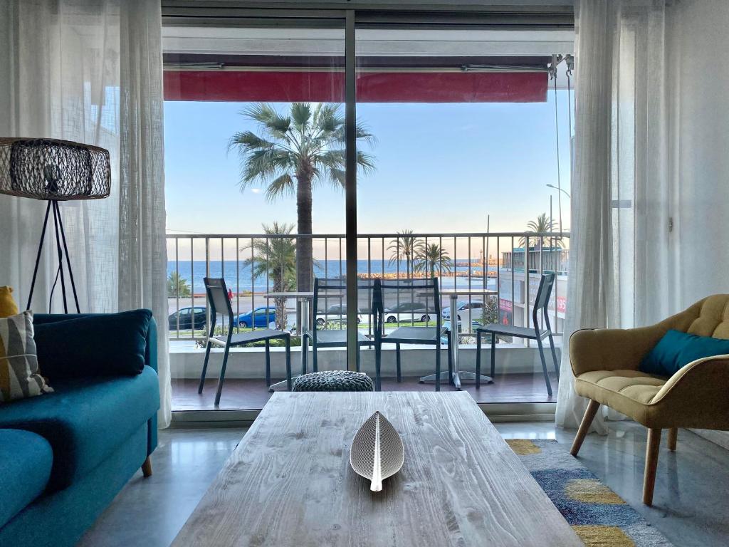 a living room with a table and a view of the ocean at "Le rêve éveillé", vue mer, garage in Menton