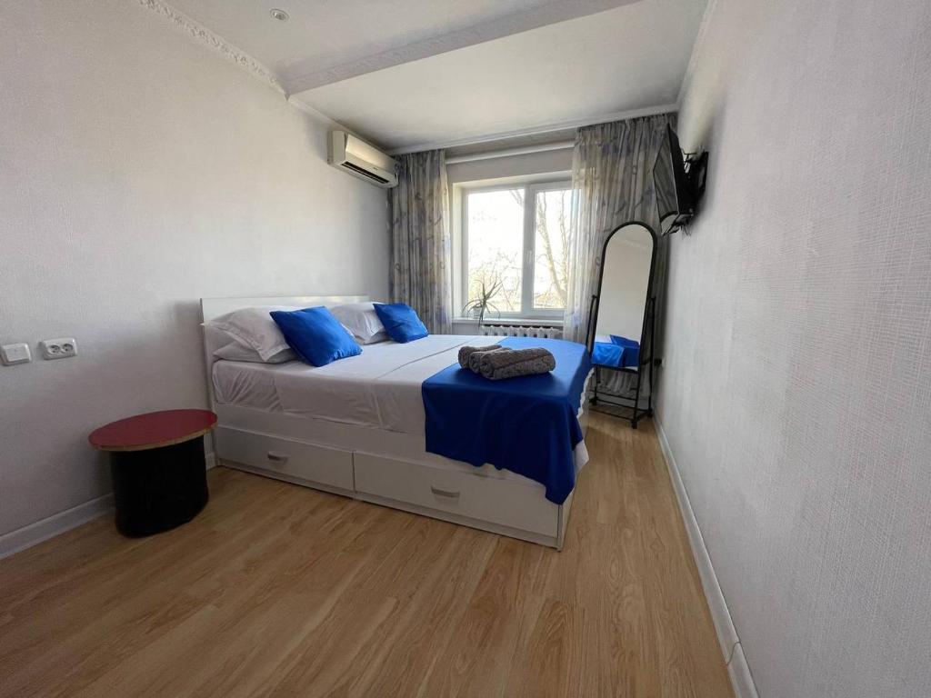 シムケントにあるДомашний уютのベッドルーム(青い枕と鏡付きのベッド1台付)