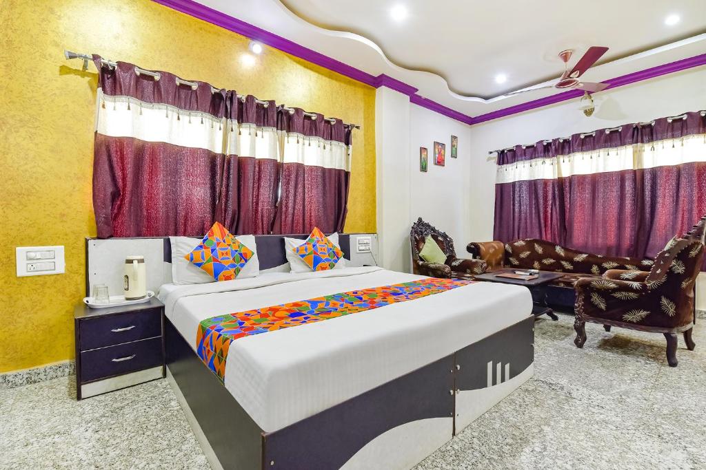 FabExpress Relax Inn I, Udaipur في أودايبور: غرفة نوم مع سرير مزدوج كبير وأريكة