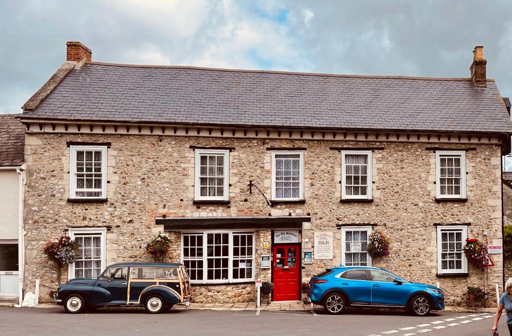 two cars parked in front of a brick building at The Old Bakehouse in Colyton