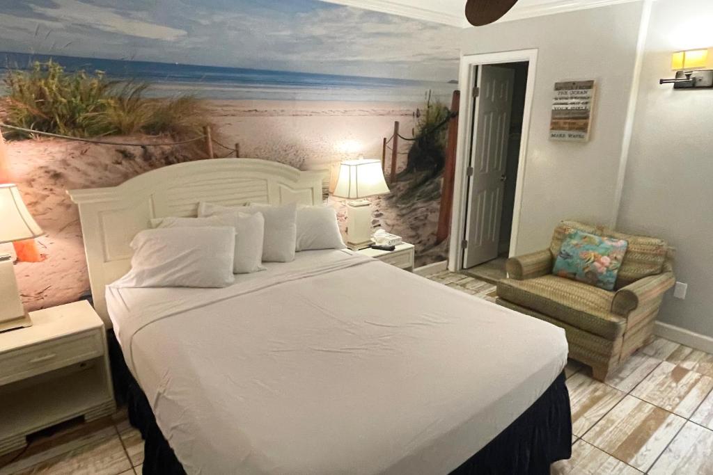 een slaapkamer met een groot wit bed en een stoel bij Beachview 208 in Gulf Shores