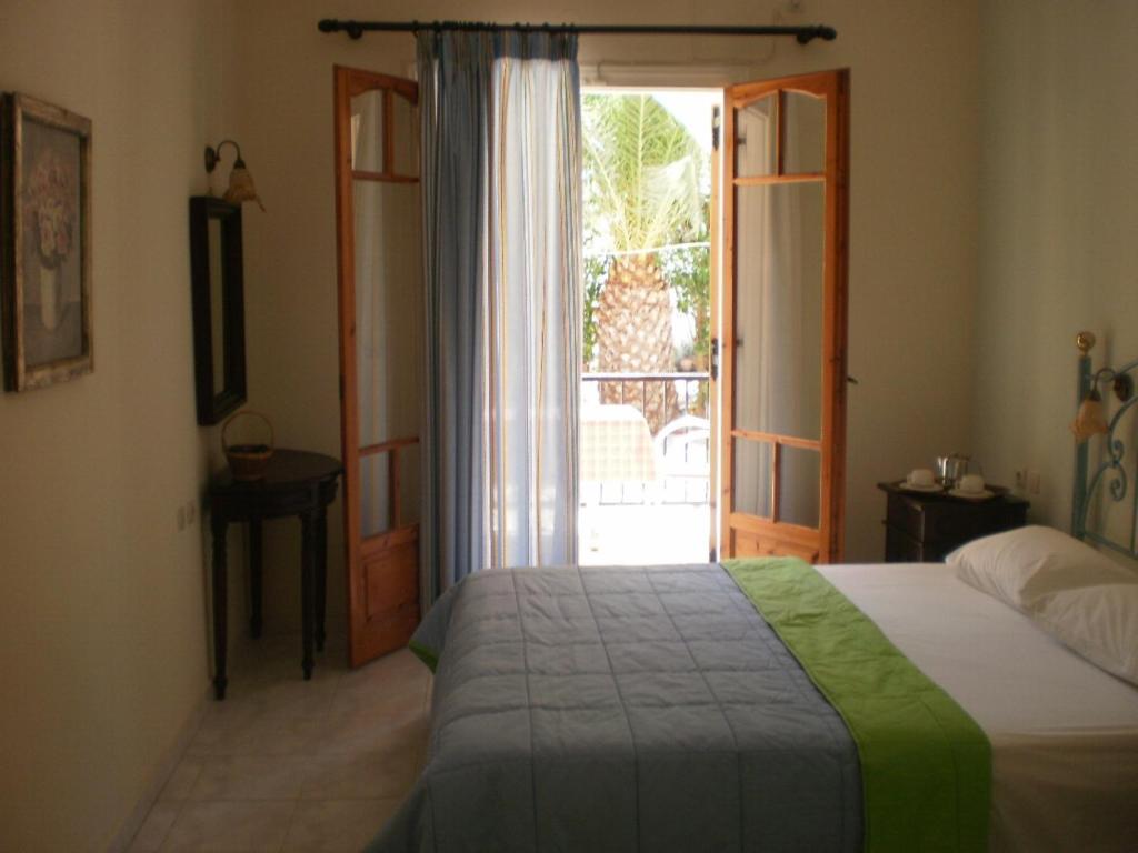 a bedroom with a bed and a sliding glass door at Loukas Inn Family Resort in Keri