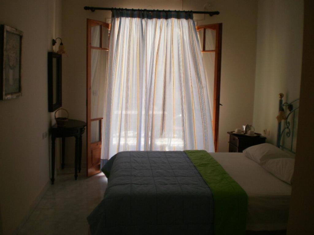 a bedroom with a bed and a window at Loukas Inn Family Resort in Keri