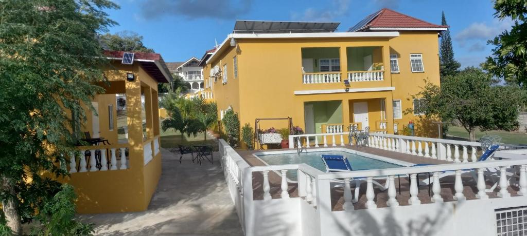 a yellow house with a swimming pool in front of it at Modrians in Runaway Bay