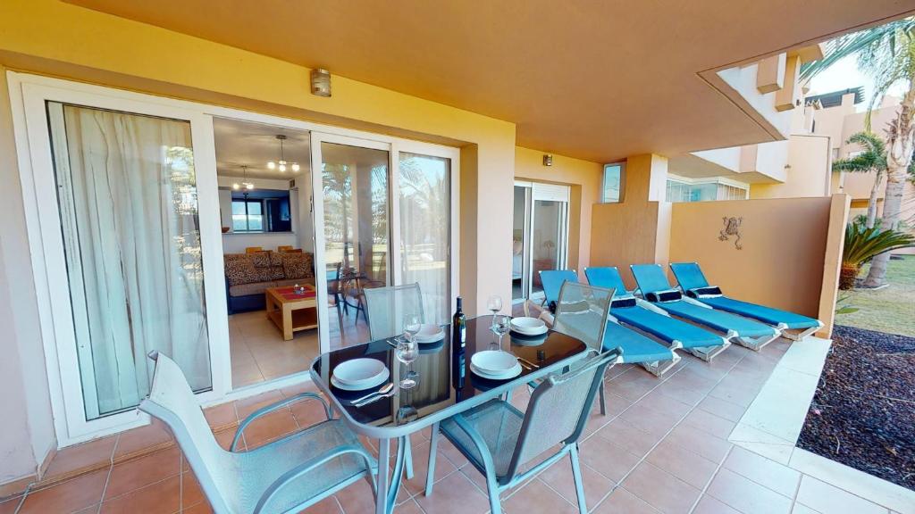 comedor con mesa de cristal y sillas en Casa Abeto A - Murcia Holiday Rentals Property, en Torre-Pacheco