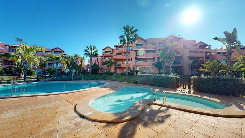 a swimming pool in front of some apartment buildings at Casa Abeto A - Murcia Holiday Rentals Property in Torre-Pacheco