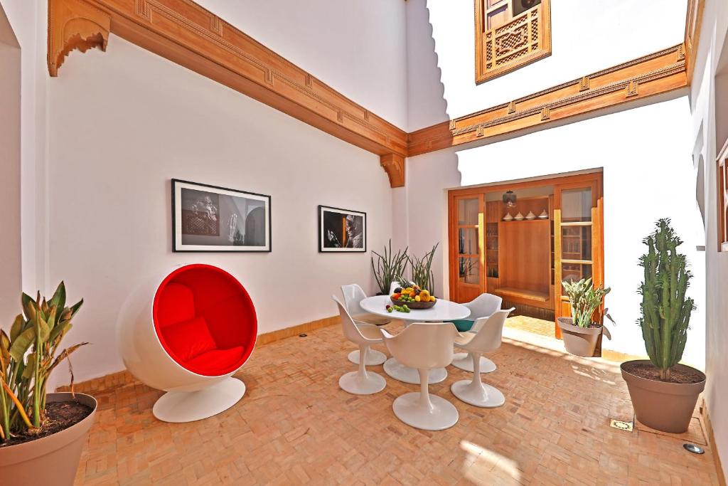 een woonkamer met een tafel, stoelen en planten bij RIAD THE MILESTONE in Marrakesh