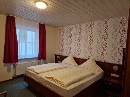 a bedroom with a large bed with a window at Hotel Weinhaus Am Stiftstor in Treis-Karden