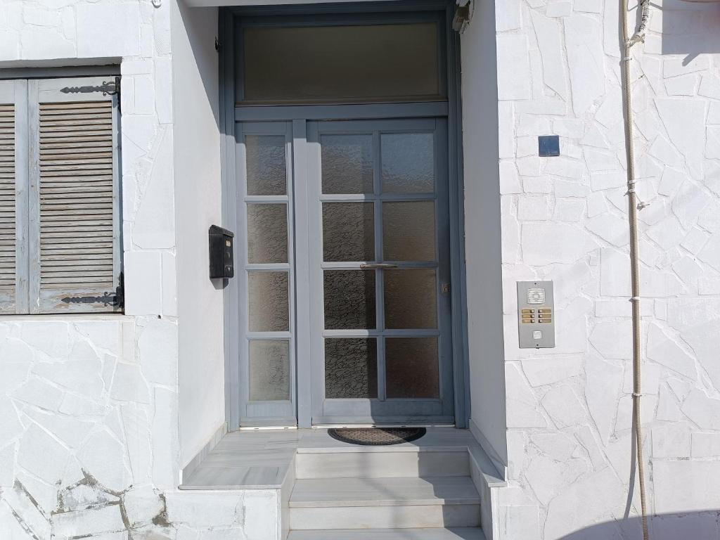 a gray door on a white building at Anna's Home in Ermoupoli