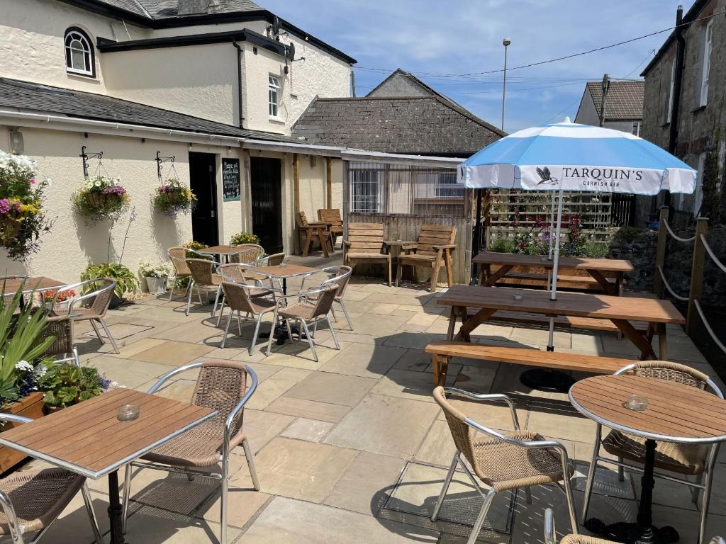 a patio with tables and chairs and an umbrella at The Duke of Cornwall in St Austell