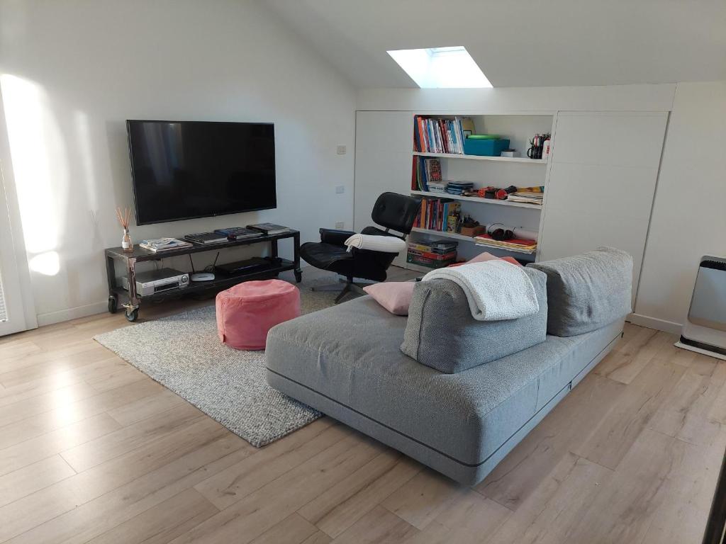 salon z kanapą i telewizorem z płaskim ekranem w obiekcie Mansarda Olgiati zona Navigli w Mediolanie