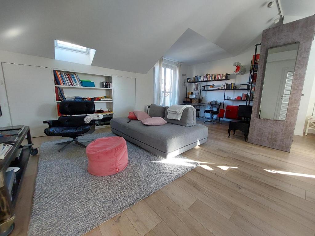 salon z szarą kanapą i krzesłem w obiekcie Mansarda Olgiati zona Navigli w Mediolanie