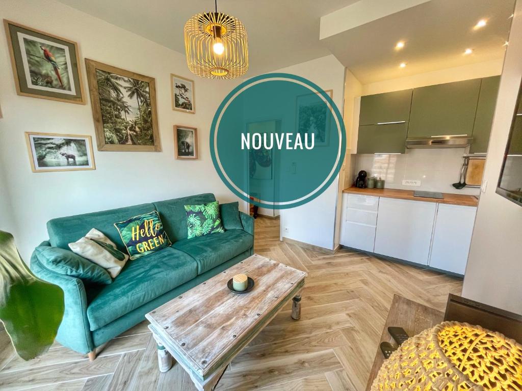 a living room with a green couch and a table at Homelivia Av Jean Médecin in Nice