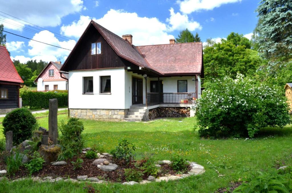 Biały dom z czarnym dachem w obiekcie Chata Doubice w mieście Doubice